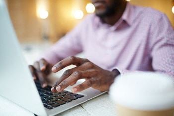 A man typing on laptop 